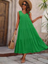 Woman wearing a green dress and straw hat, standing outdoors.